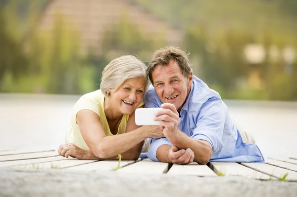 Seniorenpaar liegt auf Seebrücke — Stockfoto