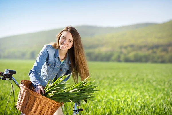 Meisje met fiets in veld — Stockfoto