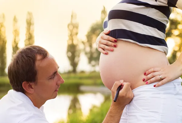 Homem escrevendo um nome na barriga — Fotografia de Stock