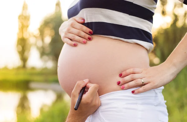 Man writing a name on belly — Stock Photo, Image