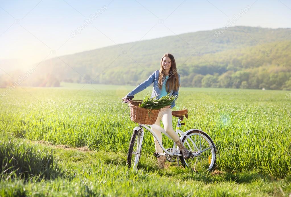 Girl with bike in field