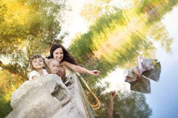 Sisters with mother playing on lake — Stock Photo, Image