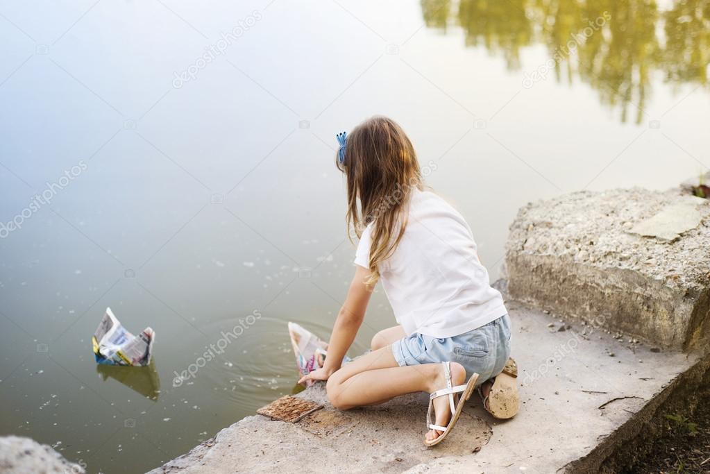 Girl playing with paper boats