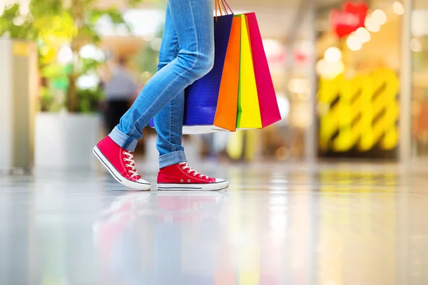 Pernas femininas com sacos de compras — Fotografia de Stock