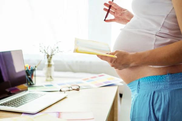 Zwangere vrouw in kantoor aan huis — Stockfoto