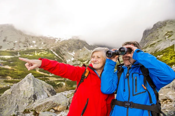 Hikers couple with binoculars — Stock Photo, Image