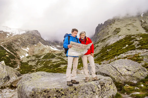 Wandererehepaar schaut auf Wanderkarte — Stockfoto