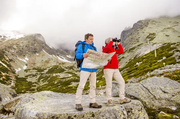 Wandererehepaar schaut auf Wanderkarte — Stockfoto