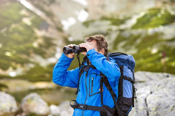 Uomo escursionista con binocolo — Foto Stock