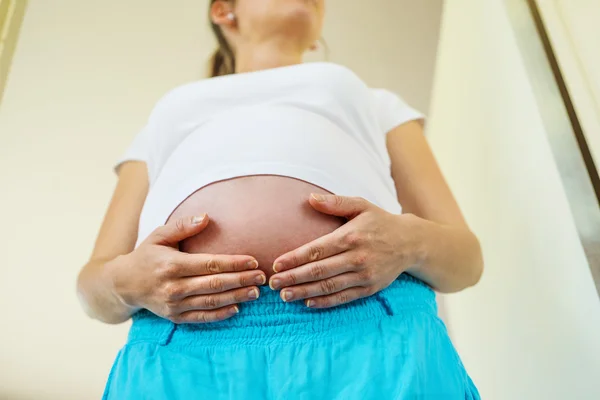 Donna incinta con mani sopra la pancia — Foto Stock