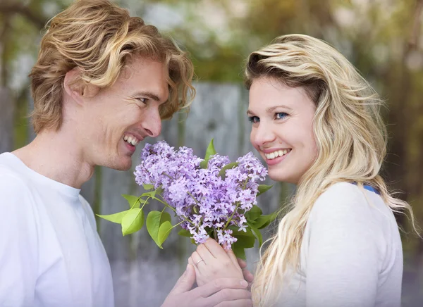 Couple with lilac flowers — Stock Photo, Image