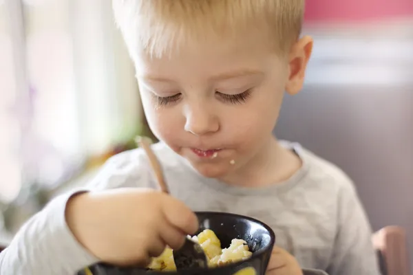 Niño comiendo pasta — Zdjęcie stockowe