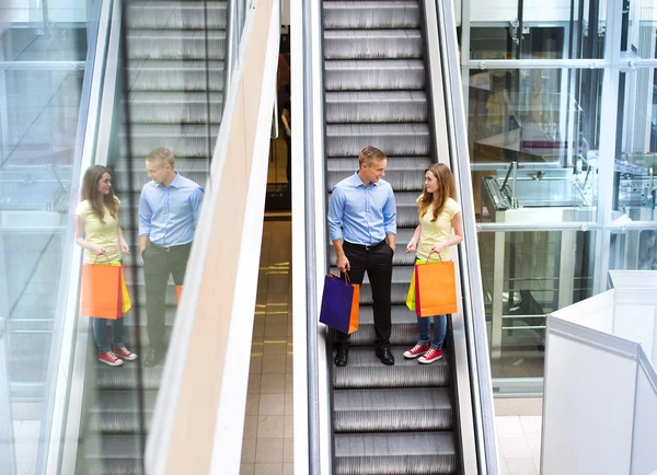 Paar fährt Rolltreppe hinunter — Stockfoto
