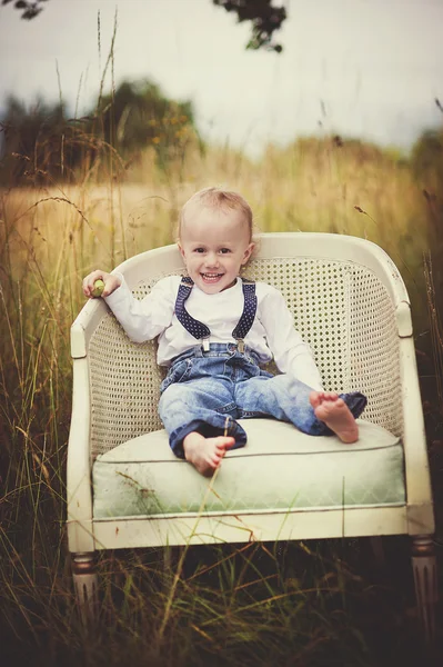Niño sentado en sillón — Foto de Stock