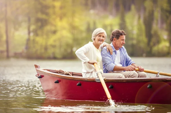Senior couple paddling on boat — Stock Photo, Image