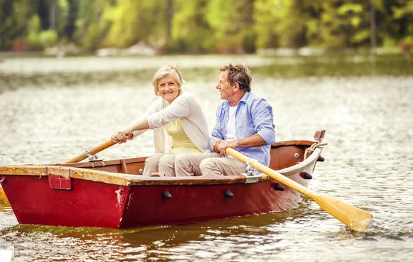 Pareja mayor remando en barco — Foto de Stock