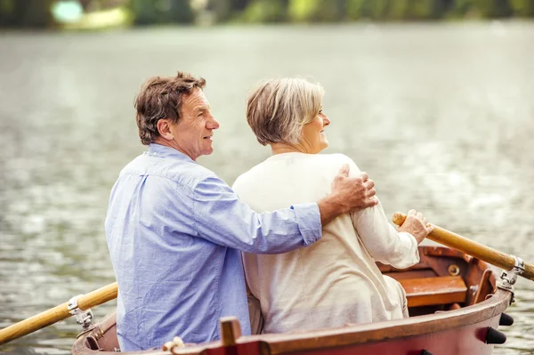 Pareja mayor remando en barco — Foto de Stock