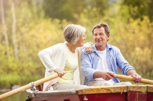 Senior couple paddling on boat — Stock Photo, Image