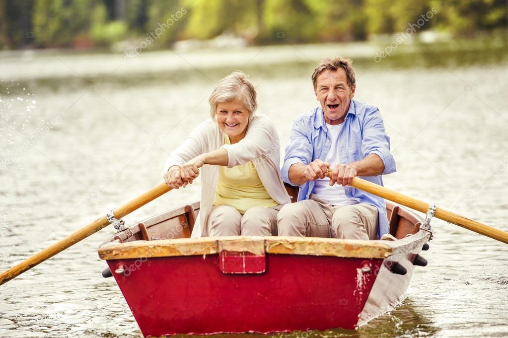 Senior couple paddling on boat
