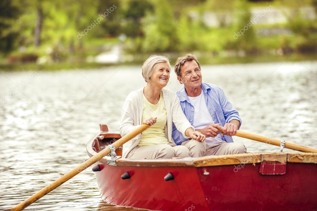 Senior couple paddling on boat