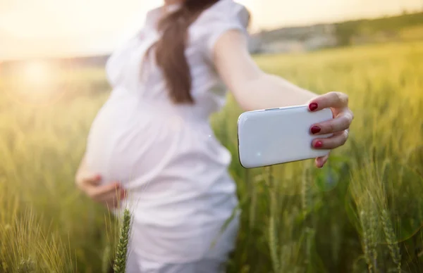 Беременная женщина делает селфи — стоковое фото