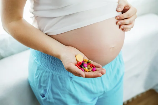 Pregnant woman holding pills — Stock Photo, Image