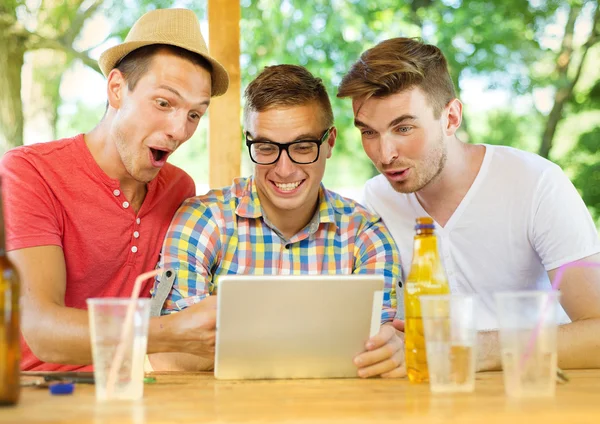 Amigos bebiendo con la tableta — Foto de Stock