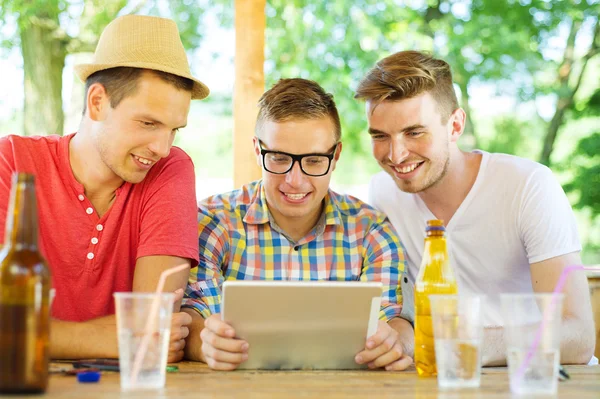 Amigos bebiendo con la tableta — Foto de Stock