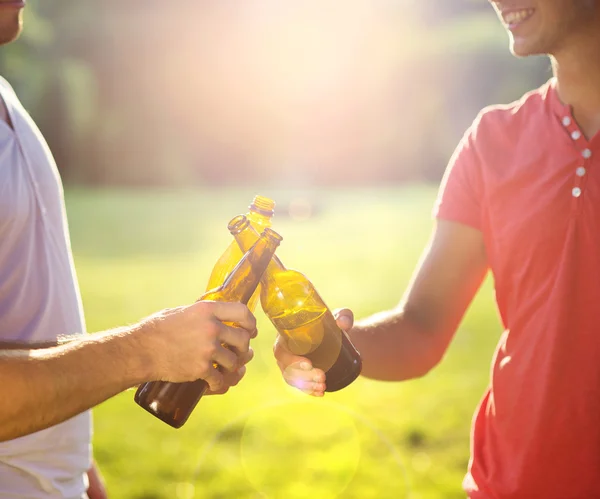 Hombres tintineo botellas de cerveza — Foto de Stock