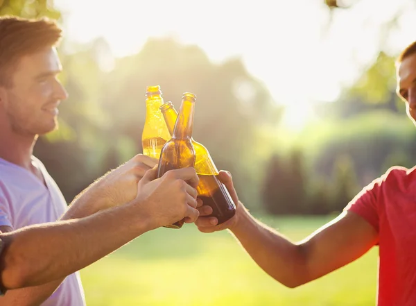 Men clinking beer bottles — Stock Photo, Image