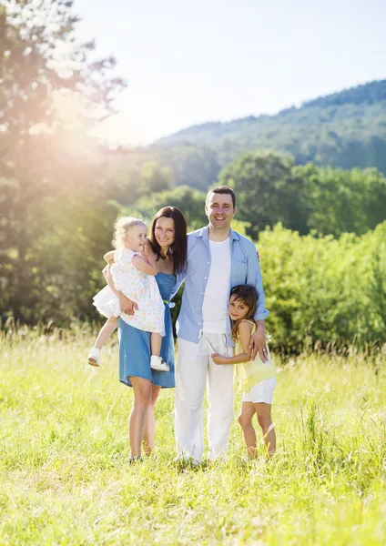 Familie wandelen in een zonnige weide — Stockfoto