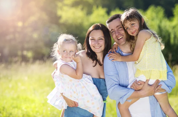 Familjen promenader i solig äng — Stockfoto