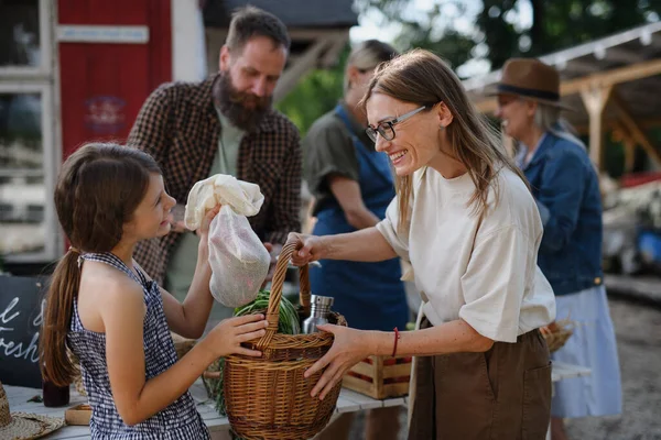 Dziewczynka z matką kupuje organiczne warzywa na targu.. — Zdjęcie stockowe