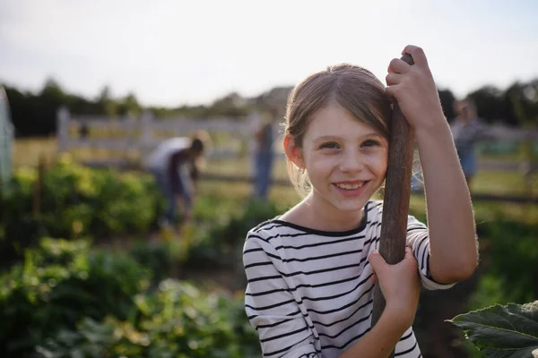 Küçük mutlu çiftçi kızın portresi, bahçedeki çiftlikte kameraya bakıyor.. — Stok fotoğraf
