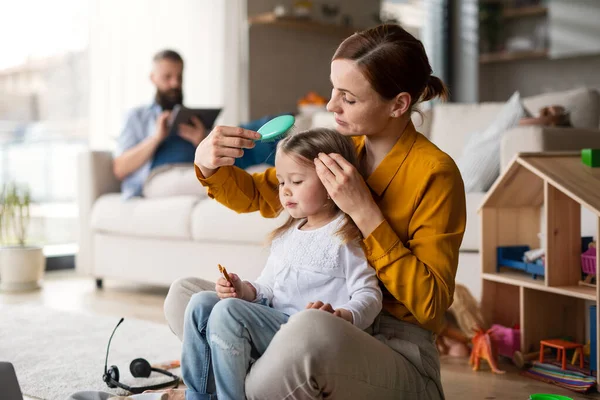 Mãe beushing cabelo para seu pequeno daugter dentro de casa, vida cotidiana e home office com conceito de criança. — Fotografia de Stock