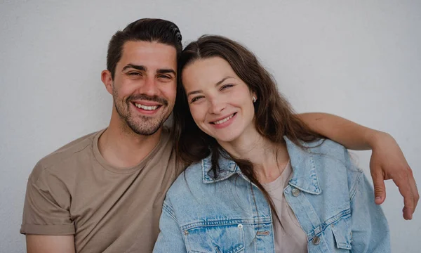 Retrato od feliz casal jovem abraçando e olhando para a câmera, no fundo branco. — Fotografia de Stock