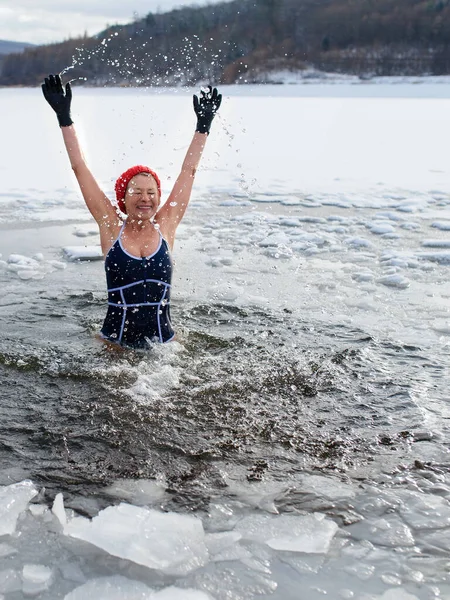 Mayo giymiş, kışın açık havaya su sıçratan, soğuk terapi konsepti olan aktif yaşlı bir kadının ön görüntüsü.. — Stok fotoğraf