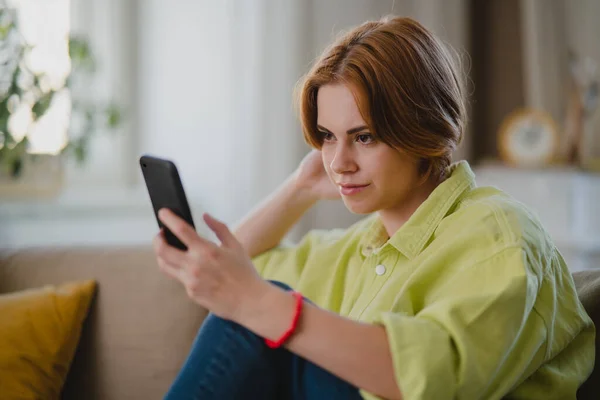 Retrato de mulher jovem usando smartphone tirando selfie, dentro de casa, conceito de redes sociais. — Fotografia de Stock