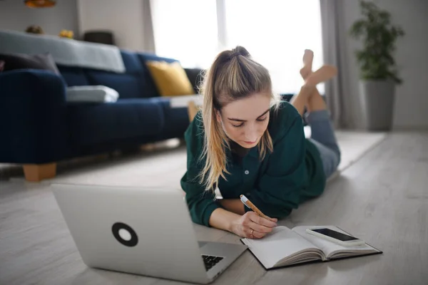 Jonge vrouw student met laptop en smartphone thuis, kantoor en leren. — Stockfoto