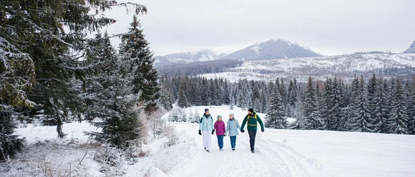 冬の自然の中で屋外を歩く小さな娘と幸せな家族、タトラ山脈スロバキア. — ストック写真