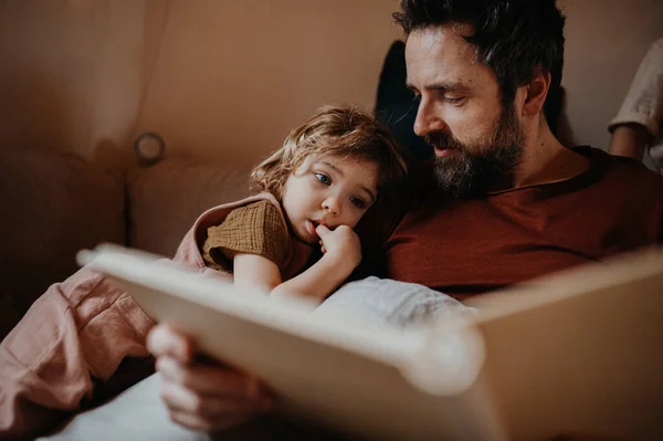 Padre maturo con piccola figlia che riposa in casa, guardando l'album fotografico. — Foto Stock