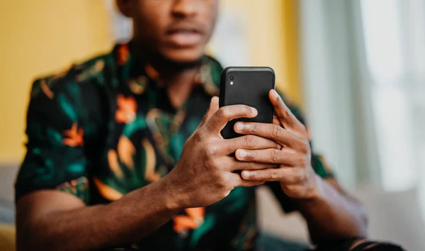 Retrato de jovem irreconhecível usando smartphone, sentado no sofá em casa, conceito de redes sociais. — Fotografia de Stock