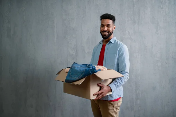 Happy young man holding packing boxes moving home, looking at camera, new living concept. — Stock Photo, Image