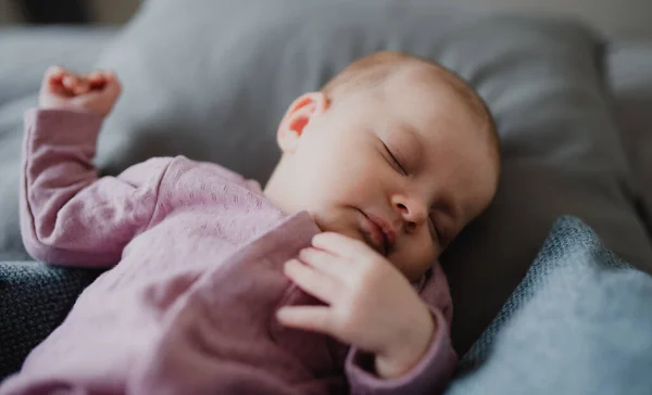 CLose up von niedlichen neugeborenen Mädchen, schlafend und liegend auf Sofa zu Hause. — Stockfoto