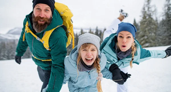 Familie mit kleiner Tochter vergnügt sich draußen in der winterlichen Natur und blickt in die Kamera. — Stockfoto
