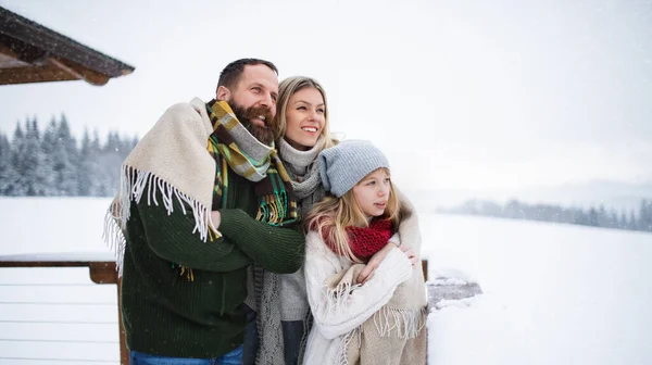 Сім'я з маленькою донькою на терасі на відкритому повітрі, відпочинок в зимовій природі . — стокове фото