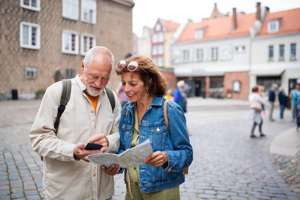 Πορτρέτο των ευτυχισμένων ηλικιωμένων τουριστών ζευγάρι χρησιμοποιώντας το χάρτη σε εξωτερικούς χώρους στην πόλη δρόμο — Φωτογραφία Αρχείου
