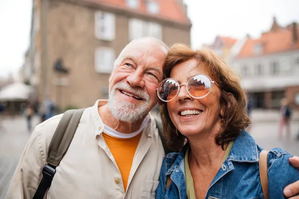 Portrét šťastného staršího páru turistů objímajících se na výletě ve městě — Stock fotografie