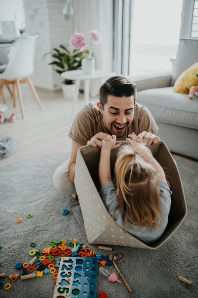 Feliz jovem pai com a filhinha brincando e se divertindo juntos em casa. — Fotografia de Stock
