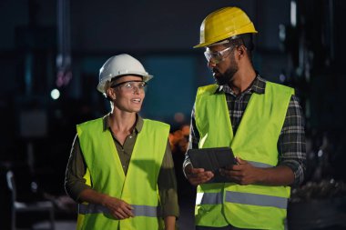 Metal atölyesinde genel bir kontrol yapan endüstriyel müfettişlerin portresi.